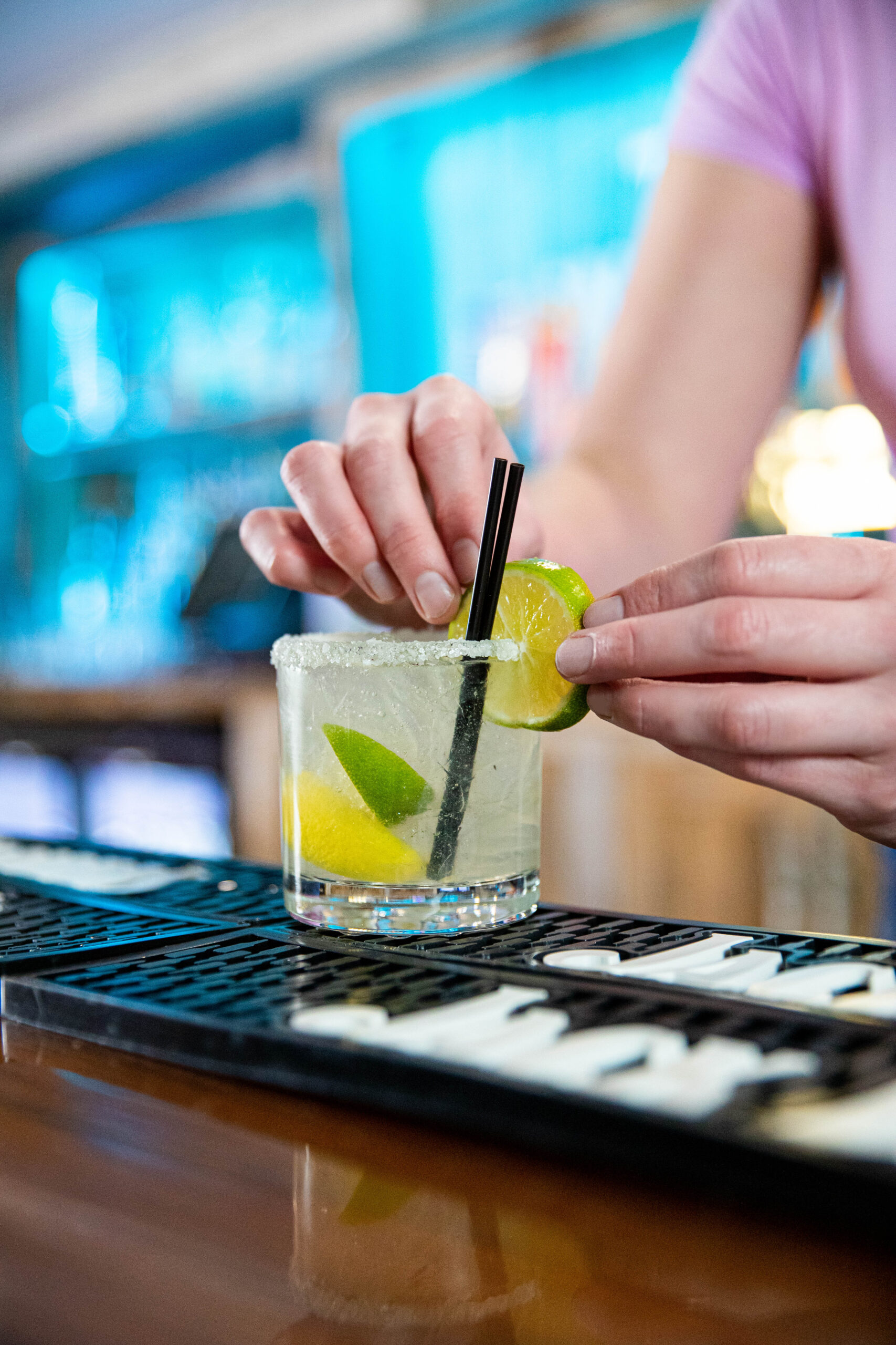 Bartender placing a lime wedge on a cocktail