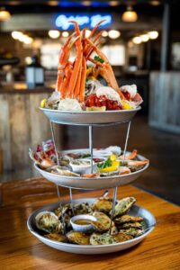 Seafood tower at The Wharf featuring oysters, crab legs, and shrimp