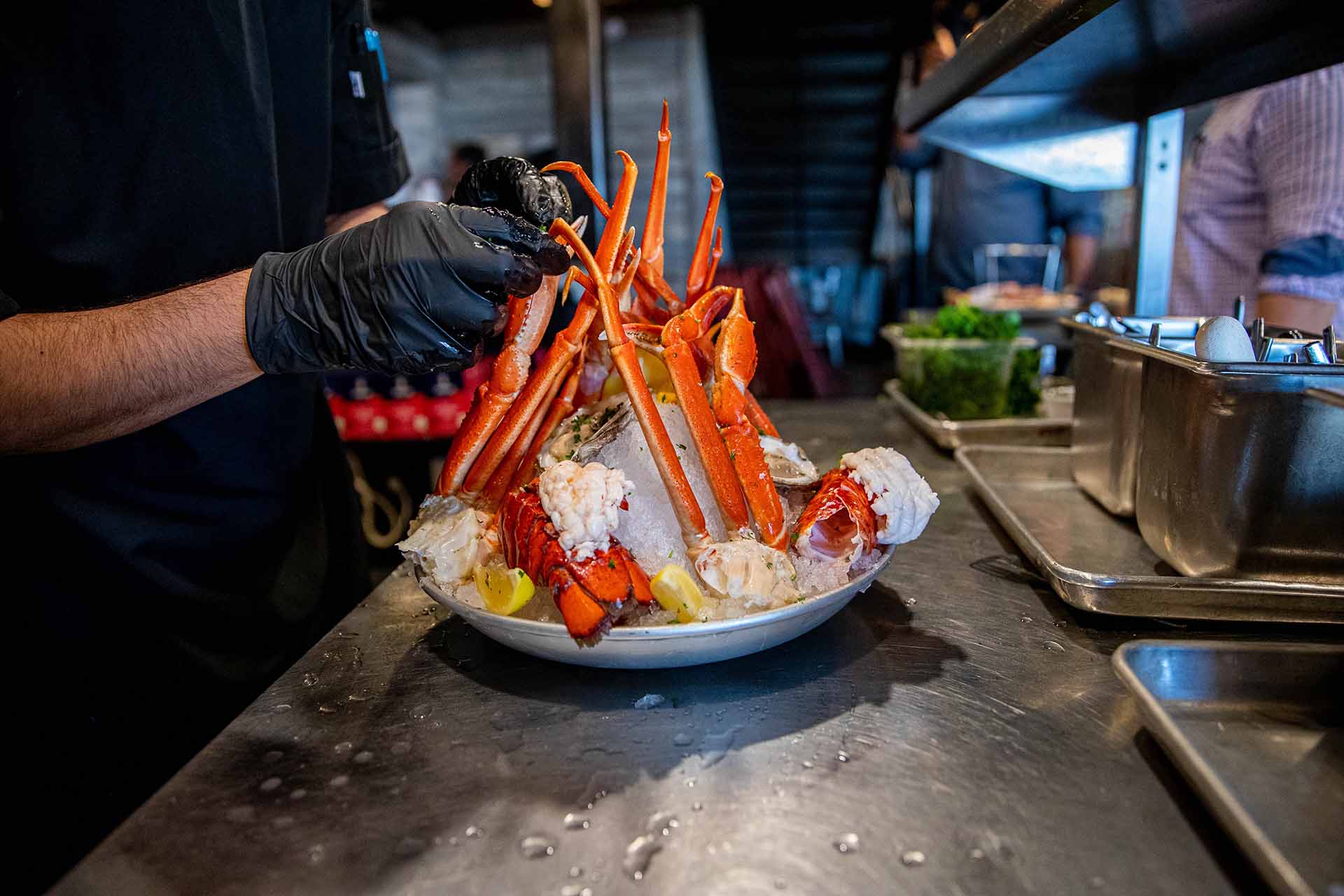 Chef putting components of the Seafood Tower onto a plate of ice at the Wharf