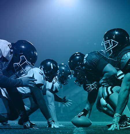 Football players positioned at the line of scrimmage